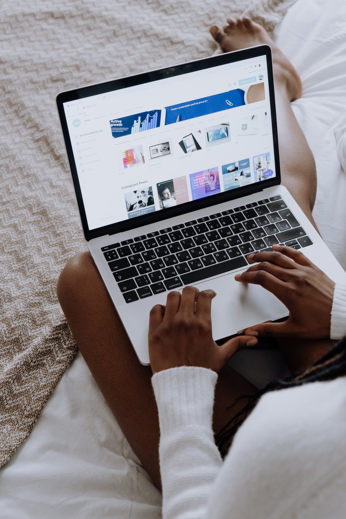 Person Using Macbook Pro on Brown Textile